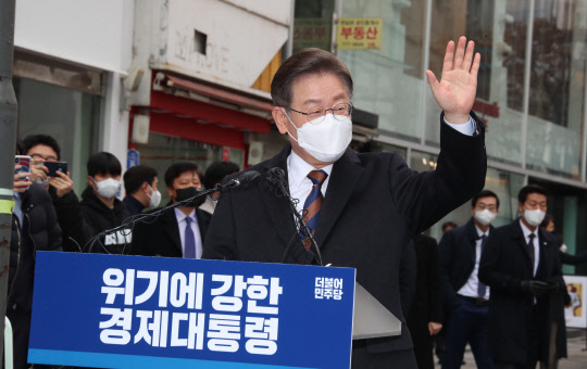 이재명 민주당 대선후보가 14일 서울 중구 명동1가 명동예술극장 사거리에서 열린 '위기극복·국민통합 선언 기자회견'에서 지지자들에게 인사하고 있다. 국회사진기자단=연합뉴스